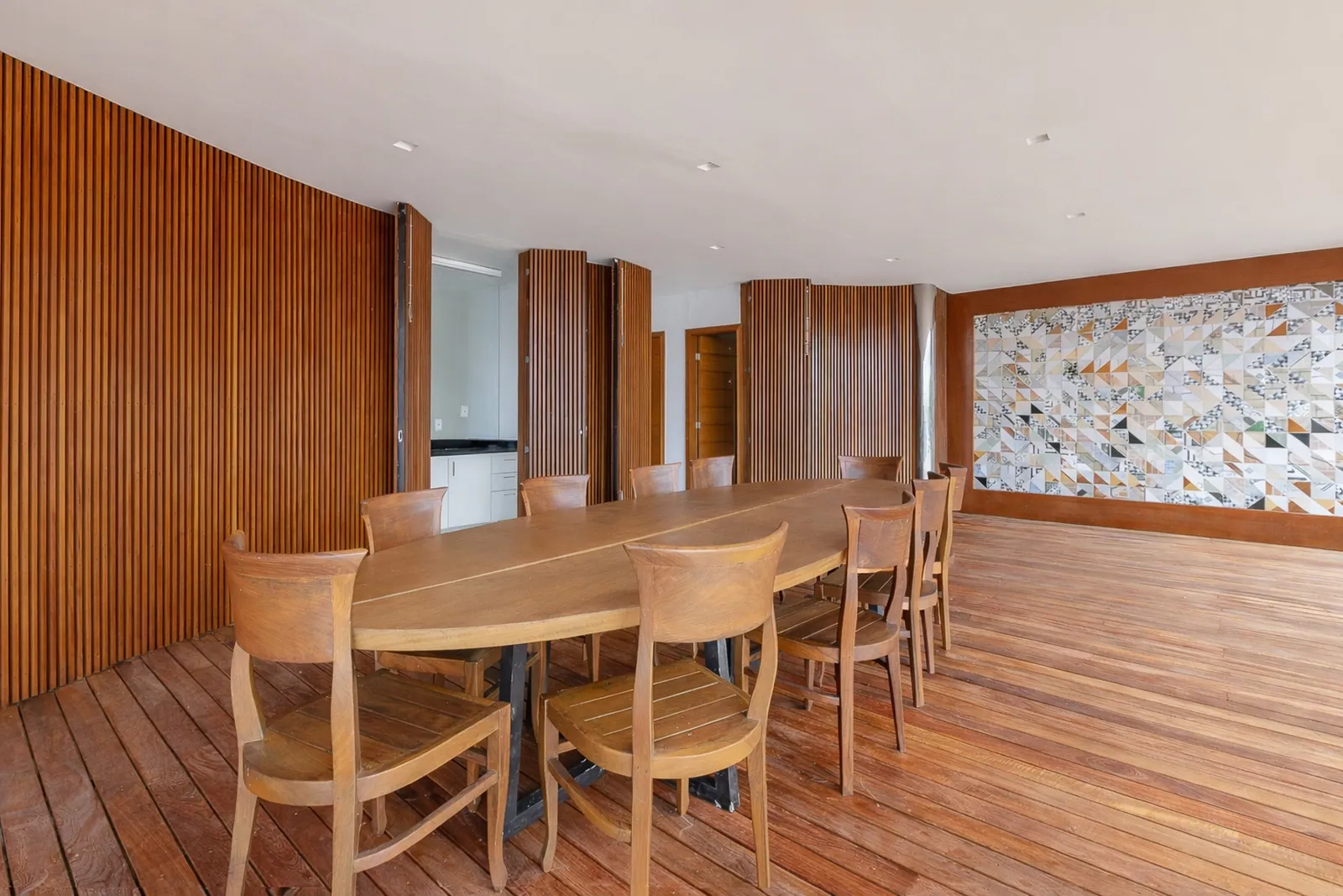 Comedor revestido en madera, con un mural mineral en la pared