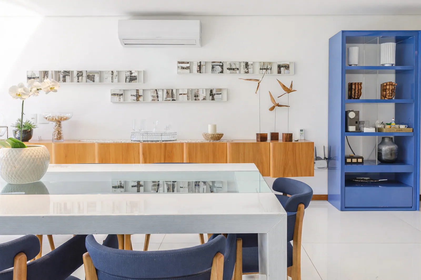 Zona de comedor con estantería azul y mesa blanca
