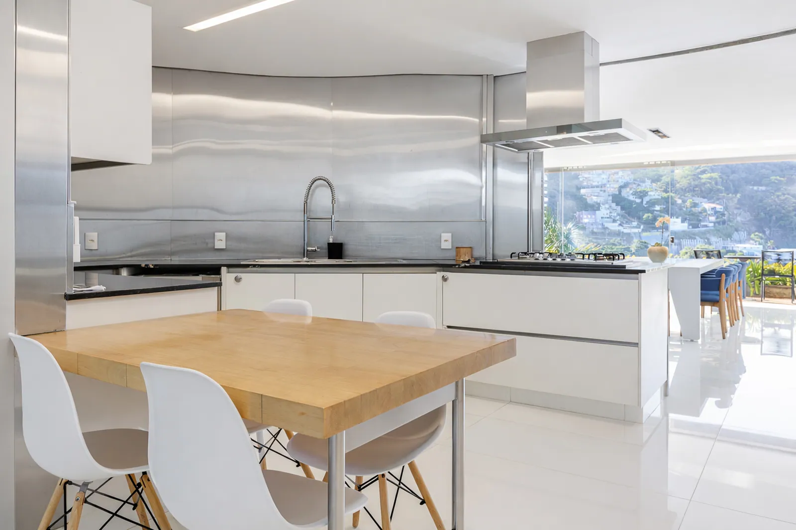 La isla de la cocina y sus taburetes, abriéndose a la terraza