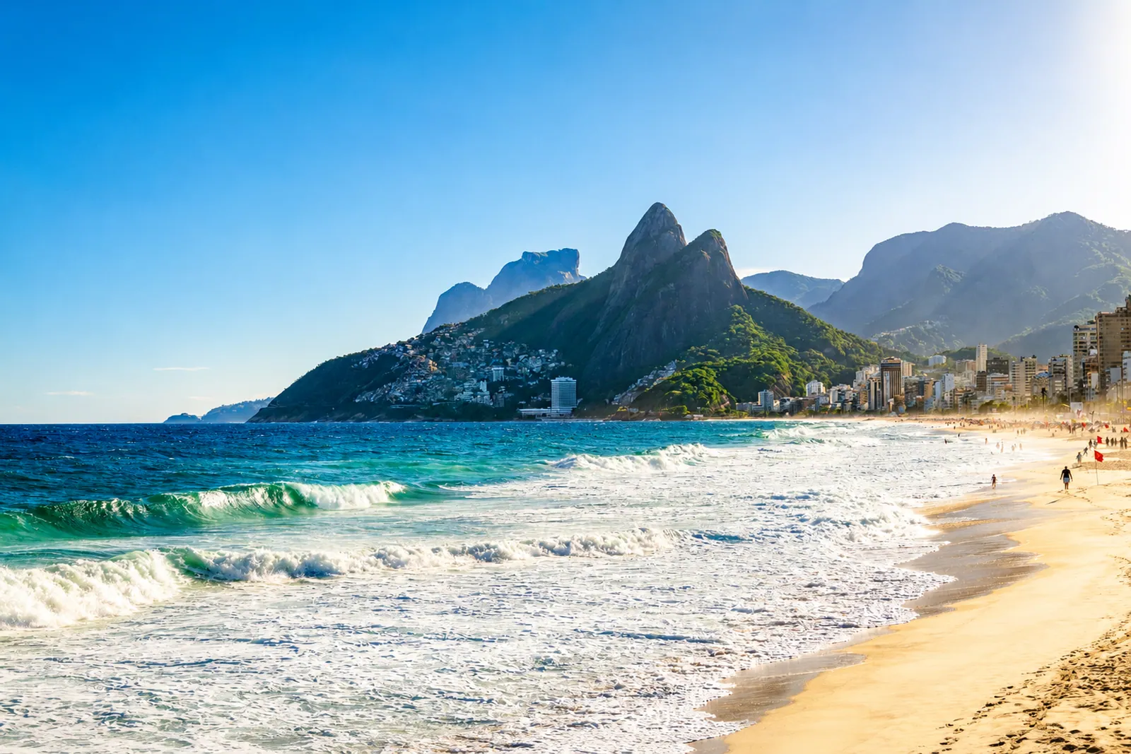 Los Dois Irmãos sobre la playa, con las olas rompiendo abajo
