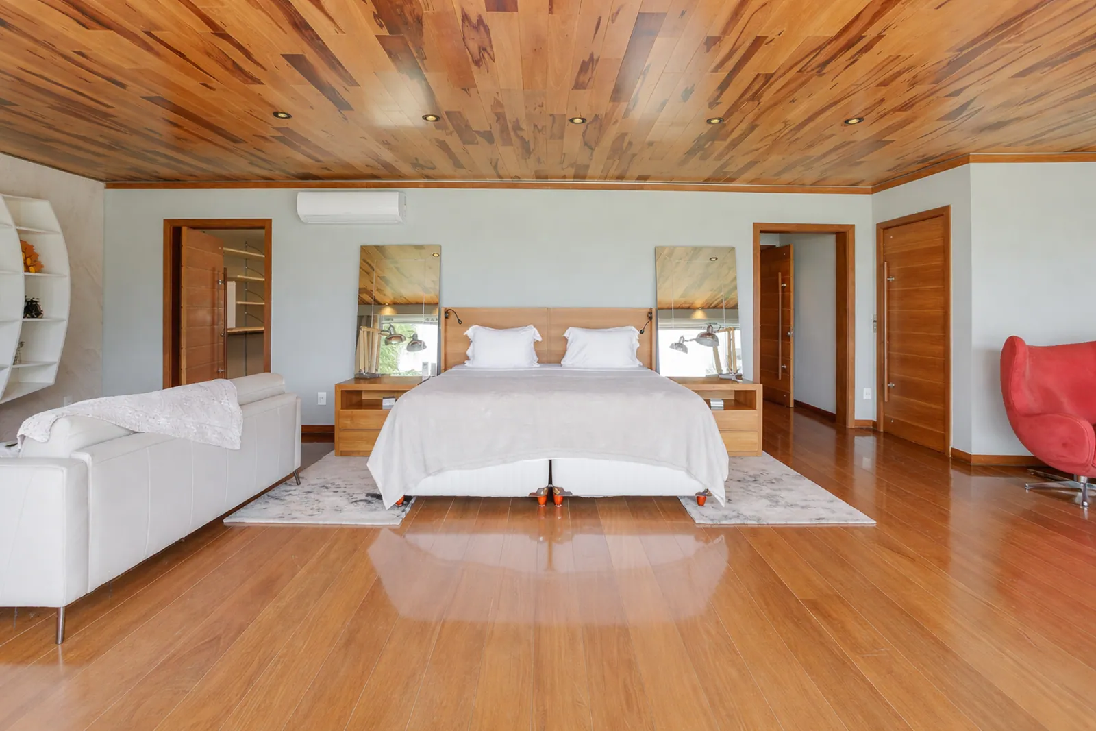 Dormitorio con techo y suelo de madera, el jardín a través del cristal