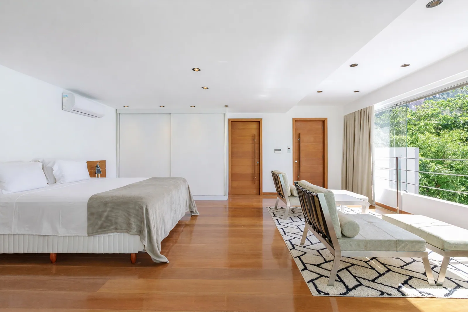 Dormitorio con suelo de madera y luz a lo largo de todo el cristal