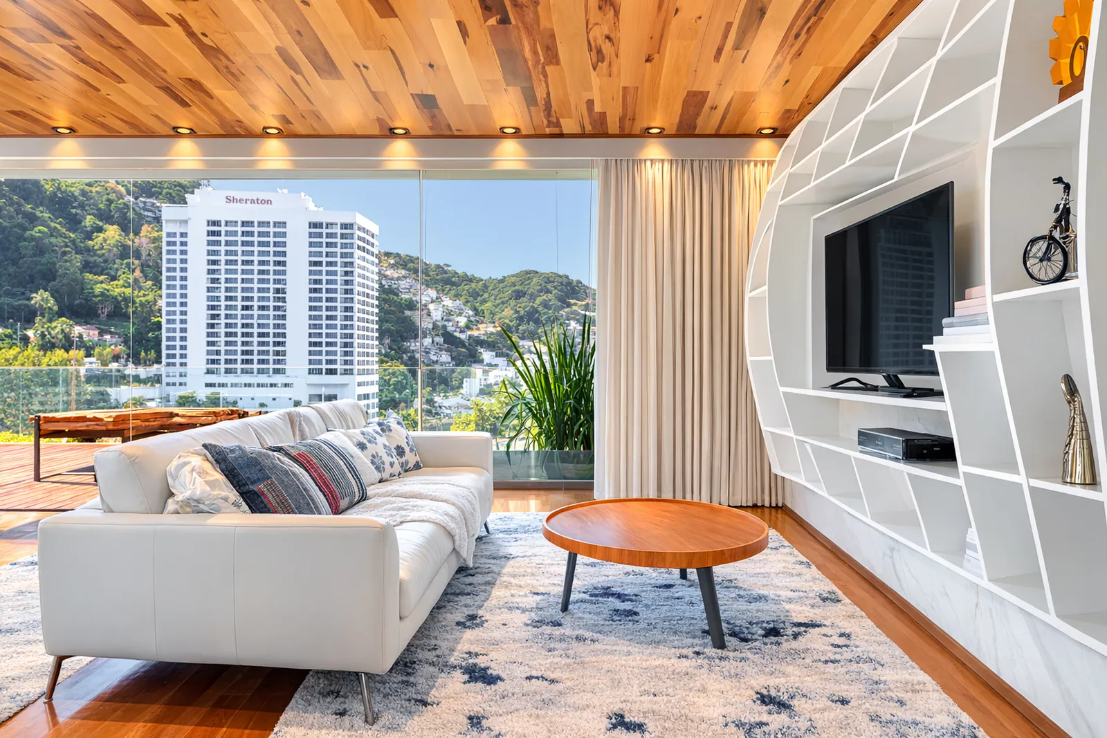 Sala de televisión bajo el techo de madera, el mar por la ventana