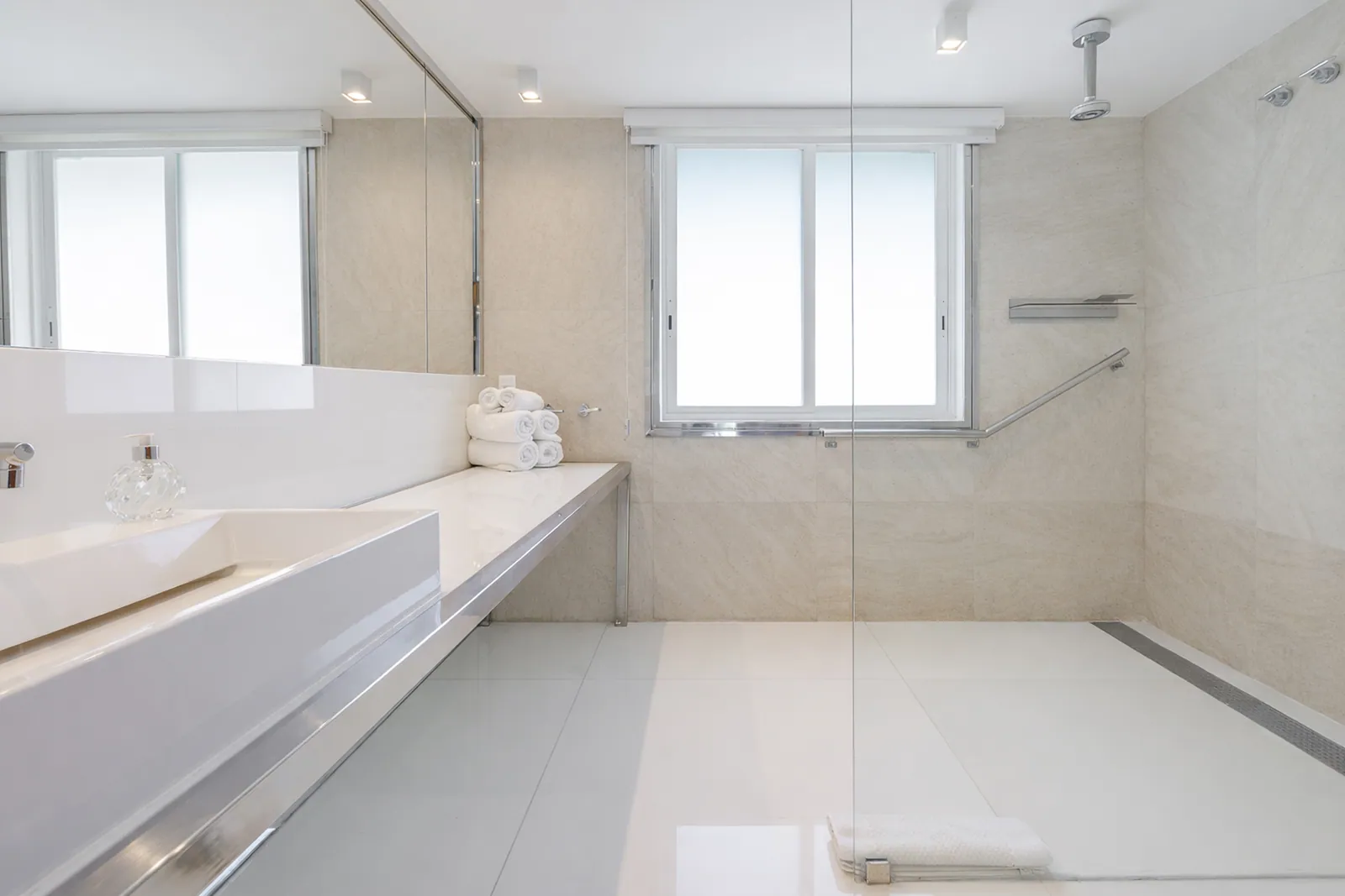 Baño en mármol con bañera y ducha a ras de suelo